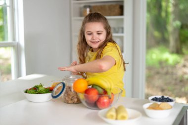 Çocuk mutfakta sağlıklı kahvaltı yapıyor. Mutfak masasındaki çocuk. Mutfakta yemek yiyen mutlu çocuk. Aile yemeği sırasında çocuk. Küçük çocuk beyaz mutfakta yemek yiyor.
