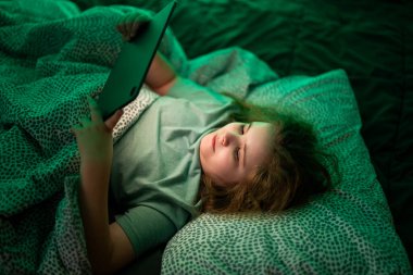 Çocuk tablette uygulamayla oynuyor. Tablette film izleyen bir çocuk. Karanlık odada tablet kullanan bir genç. Dijital tablet zamanının keyfini çıkaran çocuk