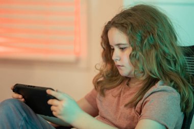 Çocuk joystick ile video oyunu oynuyor. Oyun kumandası kullanan çocuk oyun konsolu oyunu oynuyor. Evde oyun kumandası kullanan bir genç. Çocuk çevrimiçi bilgisayar oyunları oynuyor. Video oyunu