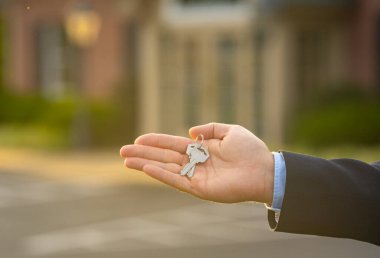 Bir emlakçı emlak satın aldıktan sonra anahtarları verir. Yeni alınmış bir dairenin anahtarları ev sahibinde. Bir emlakçı evin anahtarlarını gösteriyor. Müşteri konutun anahtarlarını alır