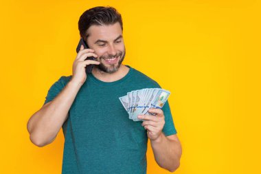 Para nakit, dolar banknotları konsepti. Elinde bir deste para tutan adamın portresi. Dolar, kredi, internet bankacılığı. Dolar banknotlarını, banka kredisini, mali tasarrufları gösteren zengin bir adam.