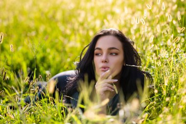 Yaz aylarında huzurlu yeşil çayırlarda dinlenen hayalperest kadın. Sakin yaşam tarzını ifade eden yaz uykusu modeli. Yaz tatili kızı sıcak güneş ışığı altında. Yaz uykusu özgürlük doğa uyumu