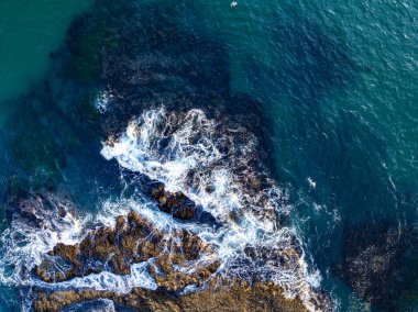 Turquoise sea with foam texture. Ocean waves from top. Powerful ocean waves. Tropical sea aerial. Aerial view of ocean waves. Ocean landscape top view. Rocky coast with sea foam. Dramatic coastline