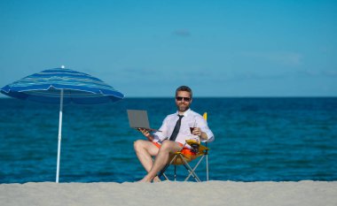 Uzaktan kumandalı yazlık deniz plajında çalışıyor. Tropik plaj tatili sırasında dizüstü bilgisayarı olan bir iş adamı. Boş bir hafta sonu ve uzak bir serbest çalışma. Çılgın komedyen deniz sahilinde dinleniyor.