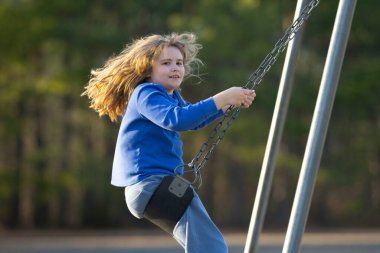 Çocuk salıncakta eğleniyor. Çocuk bahçesinde mutlu bir çocuk. Kaygısız çocuk dışarıda sallanıyor. Mutlu çocuklar dışarıda oynuyor. Sarışın çocuk heyecandan titriyor. Dışarıdaki oyuncu çocuk. Eğlenceli çocuk suratı