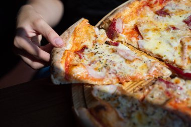 Elinde erimiş peynirle pizza. Pizza kıtır kıtır. Pizza, elinde peynirli dokularla iştahı davet eder. Pizza dilimi elinde, kapat.