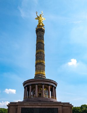 Berlin 'de mavi gökyüzünde zafer sütunları. Parlak gökyüzünün altındaki tarihi anıt. Berlin 'in üstündeki Altın Heykel Zafer Kolonu. Turistler ikonik Zafer Sütununu ziyaret ediyor. Berlin 'de mimari detaylar