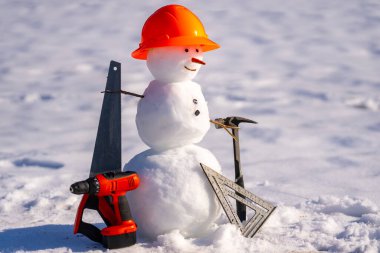 Kış kardan adam. Kasklı kardan adam mühendisi. Komik kardan adam inşaatçısı. Aletleri olan kardan adam inşaat işçisi. Kış projesinde kardan adam