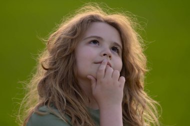 Çocuk başka tarafa bakıyor ve düşünüyor. Çocuk hayalperesti şüpheli bir bakışla düşünüyor. Derin düşünen bir çocuğun portresi. Hayalperest ergen çocuk düşüncelere daldı. Düşünceli yüzlü zeki çocuk. Hayal kuran çocuk