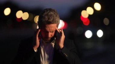 Uzun bir iş gününden sonra tükenmiş bir adam. İnsanlarla zihinsel sağlık farkındalığı konsepti. İşadamı geceleri endişeli ve yorgun. Stresli şehir hayatı portresi