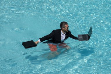 Komik şirket lideri yüzüyor. Kumsalda uzaktan kumanda. Laptopla lüks bir tatil. Bağımsız iş hayatı. İş şakası. Suda takım elbiseli yakışıklı bir çalışan. İşten sonra dinleniyorum. Kariyerde başarı