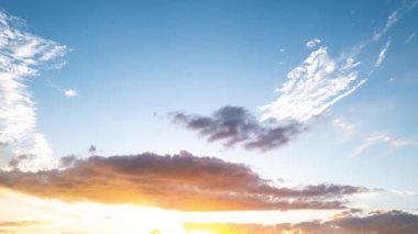 Hızlı hareket eden bulutlar sinematik bir zaman atlaması yaratır. Renkli günbatımı bulutları alacakaranlık süreleri sırasında yer değiştirir. Karanlık fırtına bulutları akşam vakti gökyüzünde süzülüyor.