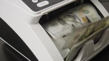 Yüz dolarlık banknotları sayıyorum. Para sayma işlemi. İş ve finans. Nakit sayma makinesi çalışıyor. Para sayma ile yatırım ve bankacılık kavramı