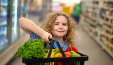 Child shopping in grocery store. Child shopping fruit at market. Shopper with vegetable. Grocery store shopping fun for kids. Kid picking fresh fruit. Child shopping at supermarket