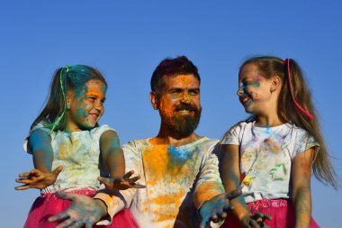 Holi renginde babaları olan çocuklar hareket halinde. Baba ve kızları Holi kutlamalarında gülen yüzlerle eğleniyorlar. Heyecanlı çocuklar babamla Holi 'yi kutluyor. Holi 'deki kızlar resim yapıyor.