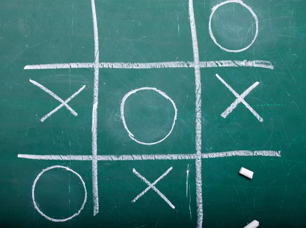 Tic-tac-toe on green blackboard — Stock Fotó