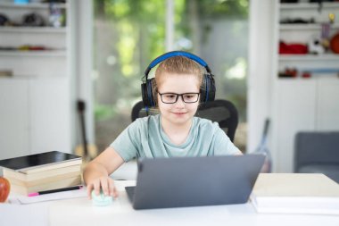 Çocuk e-öğrenme oturumunda dizüstü bilgisayarda matematik okuyor. Modern teknoloji üzerine öğrenci akışı dersi. Çocuk ev içi sınıflarda ödevlerini yapıyor. Çevrimiçi eğitim ve dijital çalışma