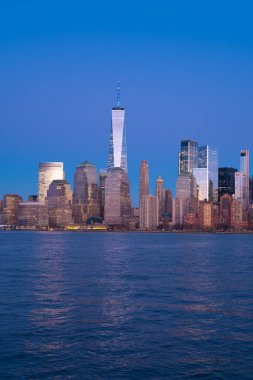 Manhattan silueti Özgürlük Kulesi ile birlikte. Dünya Ticaret Merkezi 'nin sunduğu New York silueti. Sıcak güneş ışığında New York gökdelenleri. Nehrin yukarısındaki Manhattan silueti. New York şehrinin gökyüzü geniş panorama