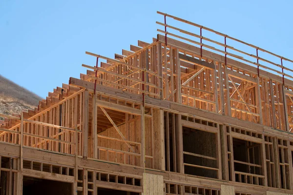 İnşaat, mavi gökyüzüne karşı ahşap iskelet gösteriyor. İnşaat binası. İnşaat, yükseldikçe yapısal ayrıntıları gözler önüne seriyor. Yapı çerçevesi ile modern gelişimi tanımlar