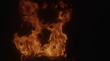 Siyah arka planda alevler. Ateş dokusu. Alevli ateş. Alev yavaş çekim. Katman efektleri için yoğun yanan ateş dokusu. Alev soyut tasarım. Parlak alevler