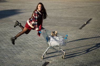 Dışarıda alışveriş yapan mutlu bir kadın. Oyuncakçı yaşam tarzı konsepti. Kentsel tüketici sevinci alışverişi. Modern perakende eğlence alışverişi
