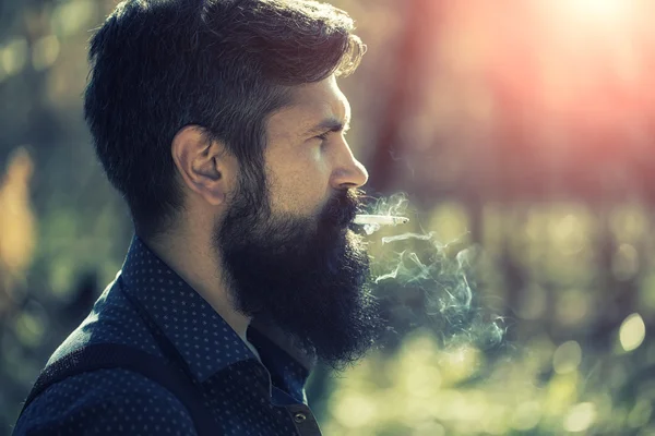 Homem fumando na floresta — Fotografia de Stock