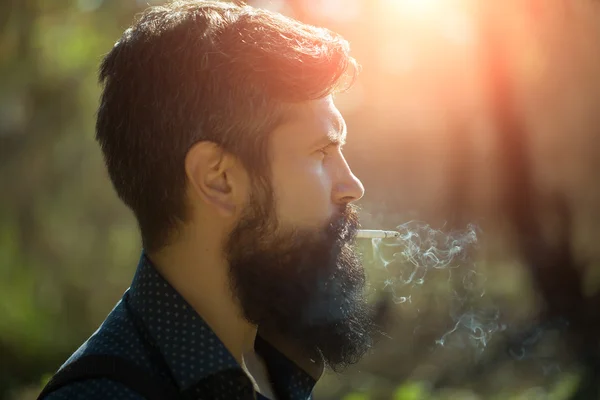 Hombre fumador en el bosque —  Fotos de Stock