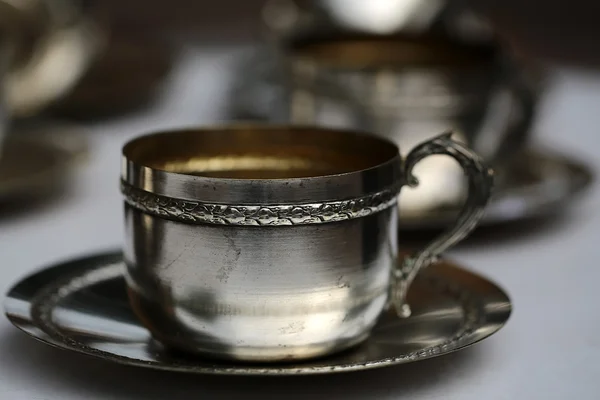 Taza de té de plata con platillo — Foto de Stock