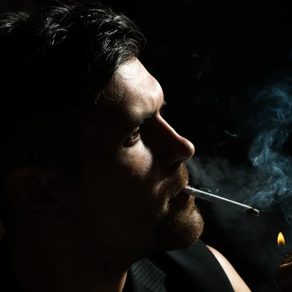 Homem não raspado acende cigarro — Fotografia de Stock
