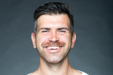 Kıl ile gülümseyen traşlı adam