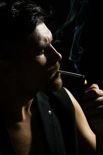Homem barbudo acende cigarro — Fotografia de Stock