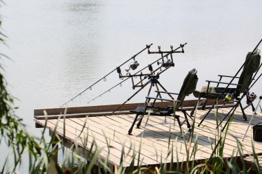 Armchairs with fishing tackle on pier