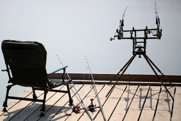 Fishing rods on wooden pier — Stock Photo, Image