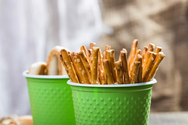 Disposable green cups with breadstuffs