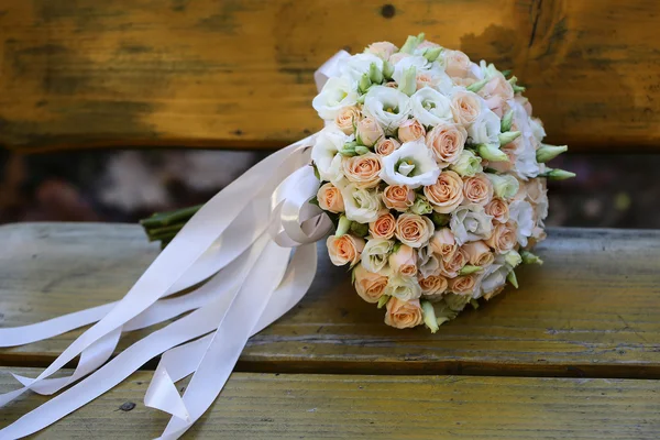Svatební kytice na dřevěné lavičce — Stock fotografie
