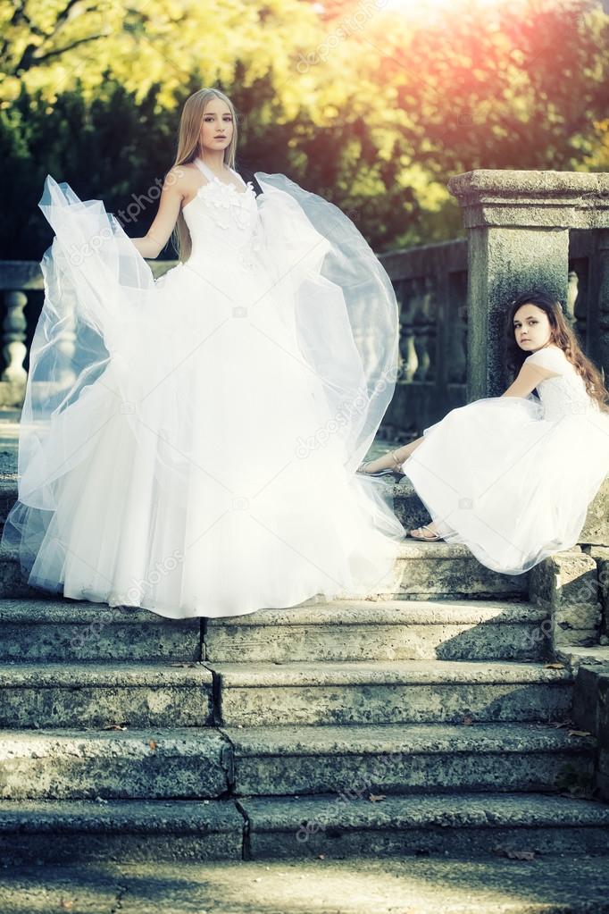 Beautiful bride with girl on stairs 