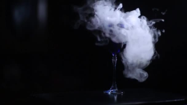 Wunderschöner Zaubertrank in einem Glas mit blauem Getränk und Dampf, blubbernder eleganter leckerer Cocktail auf schwarzem Hintergrund — Stockvideo