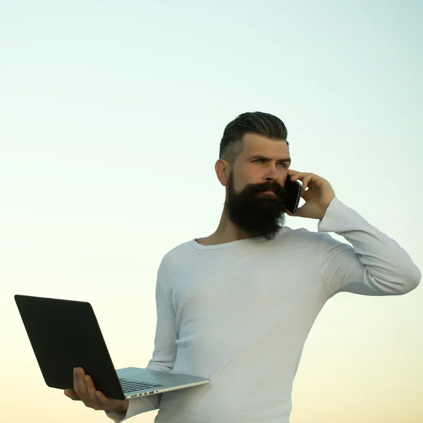 Человек с ноутбуком и телефоном — стоковое фото