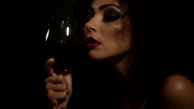 Genç çekici kız yüzünü cam ve içme şarap için presler