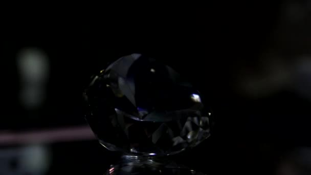 Beautiful gemstone in darkness shimmers in the rays of light — Stock Video