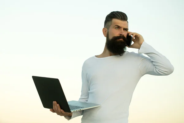 Hombre con portátil y teléfono —  Fotos de Stock