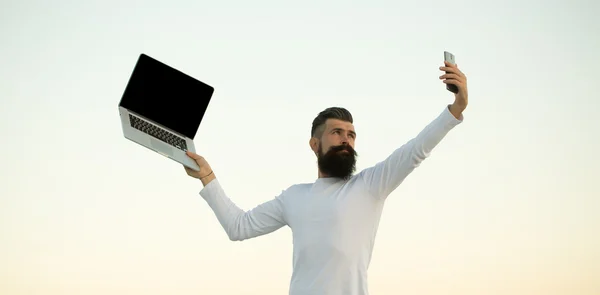 Человек с телефоном и ноутбуком — стоковое фото