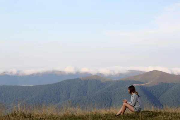 Woman with tea in mountains — Stok fotoğraf