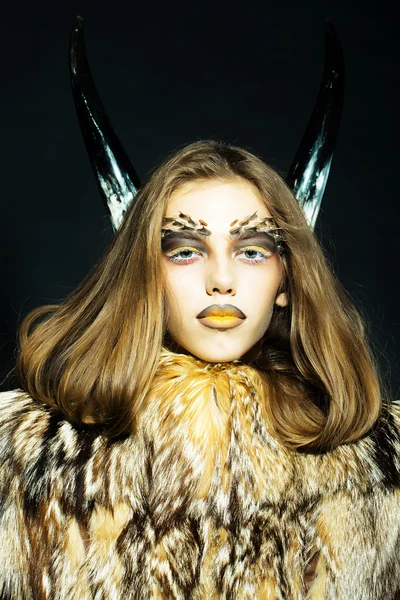 Girl with antlers and fur coat — Stock Photo, Image