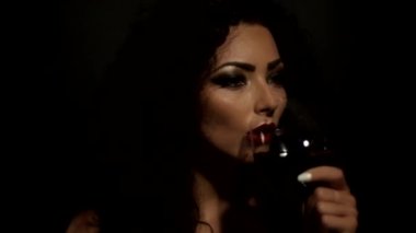 genç güzel kız gözlüklü şarap içiyor ve ışığa karşı cam şarap oynar gibi görünüyor