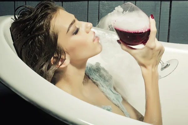 Woman with glass in bath — Stock Photo, Image