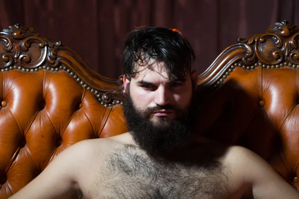 Бородатий голий чоловік на дивані — стокове фото