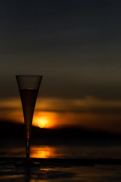 Бокал шампанского с флейтой на закате — стоковое фото