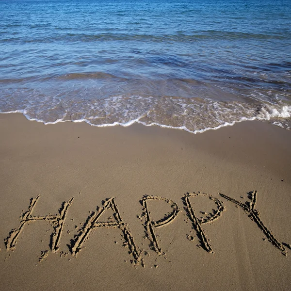 Word happy written on sand — Stock Photo, Image