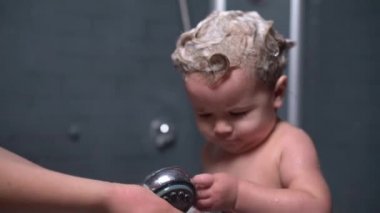 şirin güzel Bebek şampuanı saç ile annesi ellerini yıkamak için yardımcı olur.